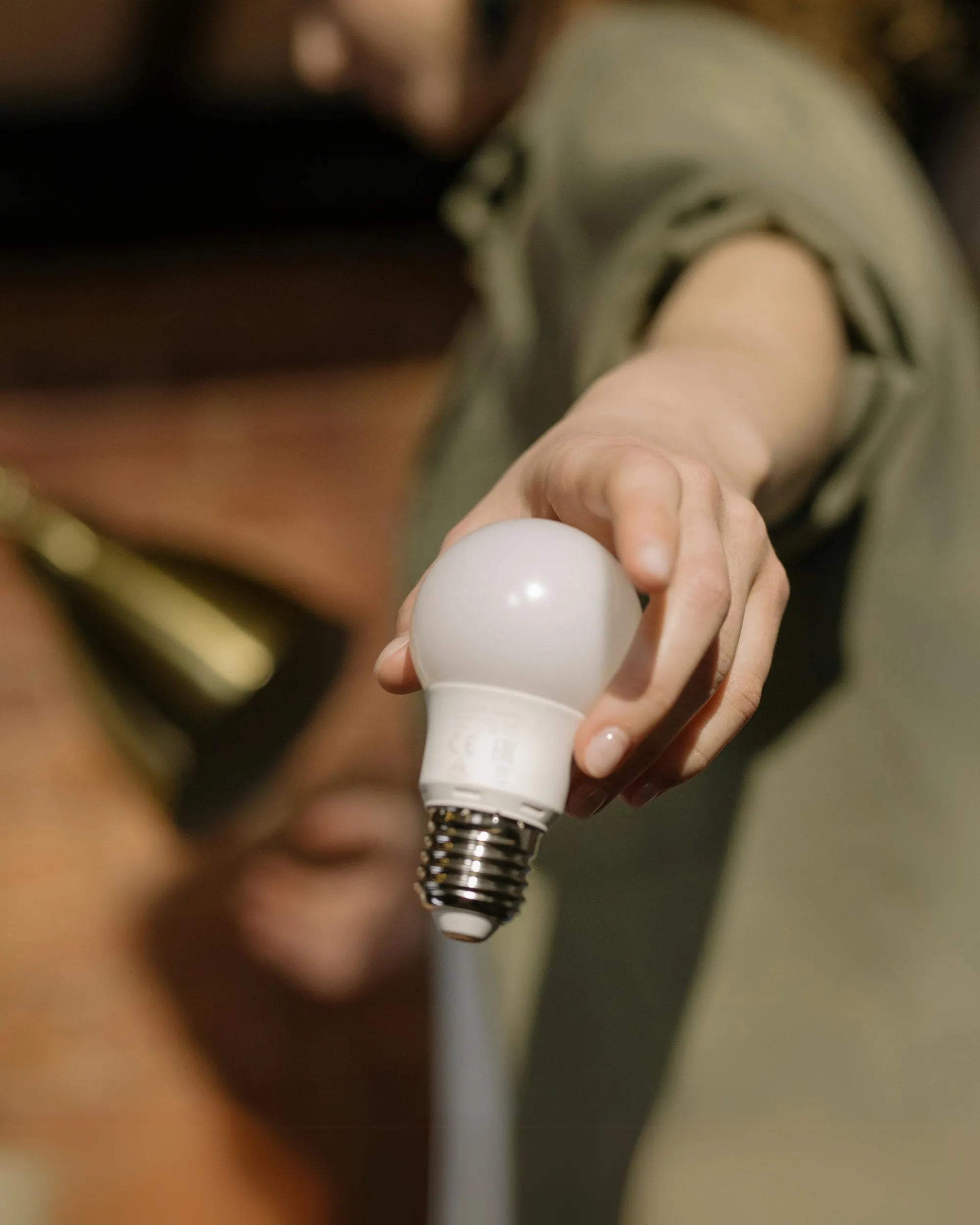 Person Handing Out A Light Bulb