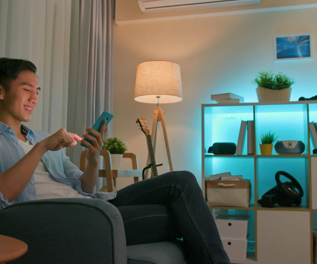 Man Smiling and Controlling Room Lights From Phone
