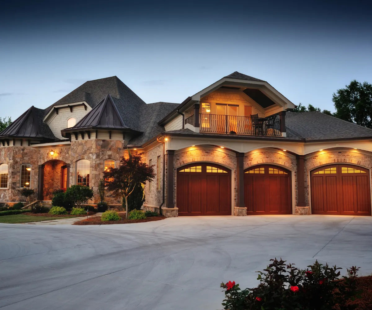 Beautiful 3-car Garage Mansion With Lights On At Sunset
