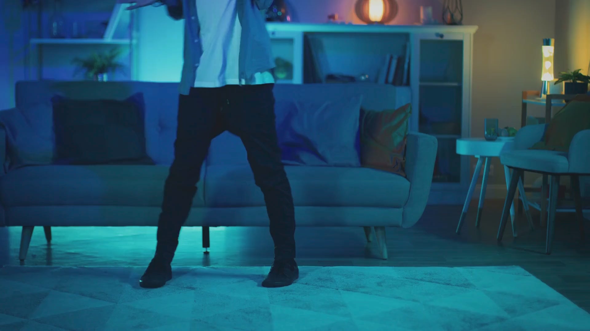 Load video: Man Dancing In Living Room Under Color-changing Light Bulb